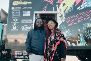 Hope Vibes nonprofit founders Emmanuel and Adrienne Threatt in front of Hope Tank vehicle