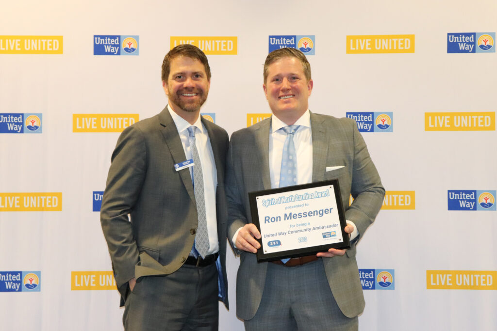 United Way Chief Development Officer Clint Hill stands with winner Ron Messenger.